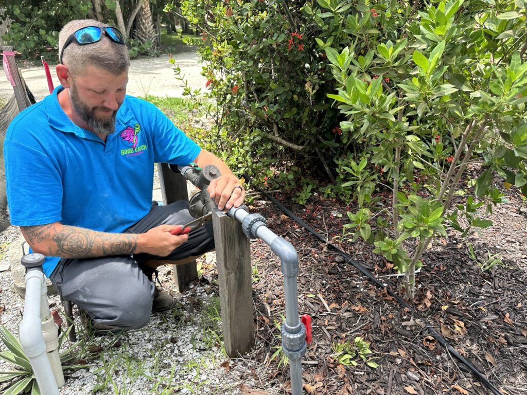 Good Catch Plumbing technician working on an outdoor plumbing valve