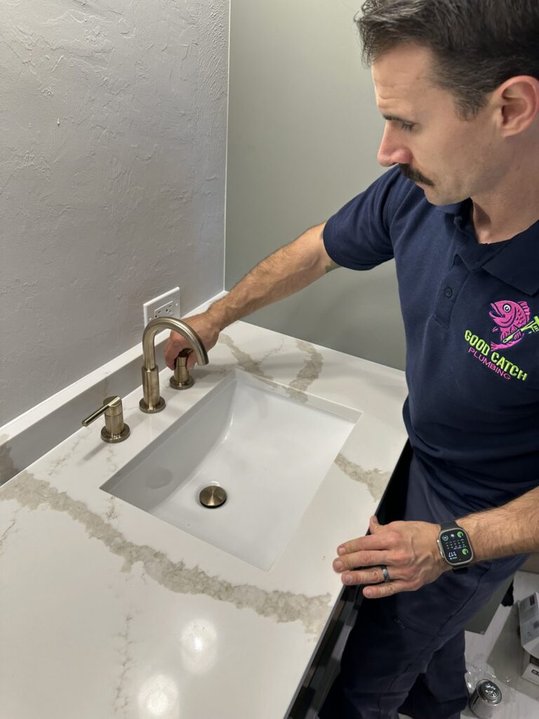 Good Catch Plumbing technician checking a bathroom sink faucet