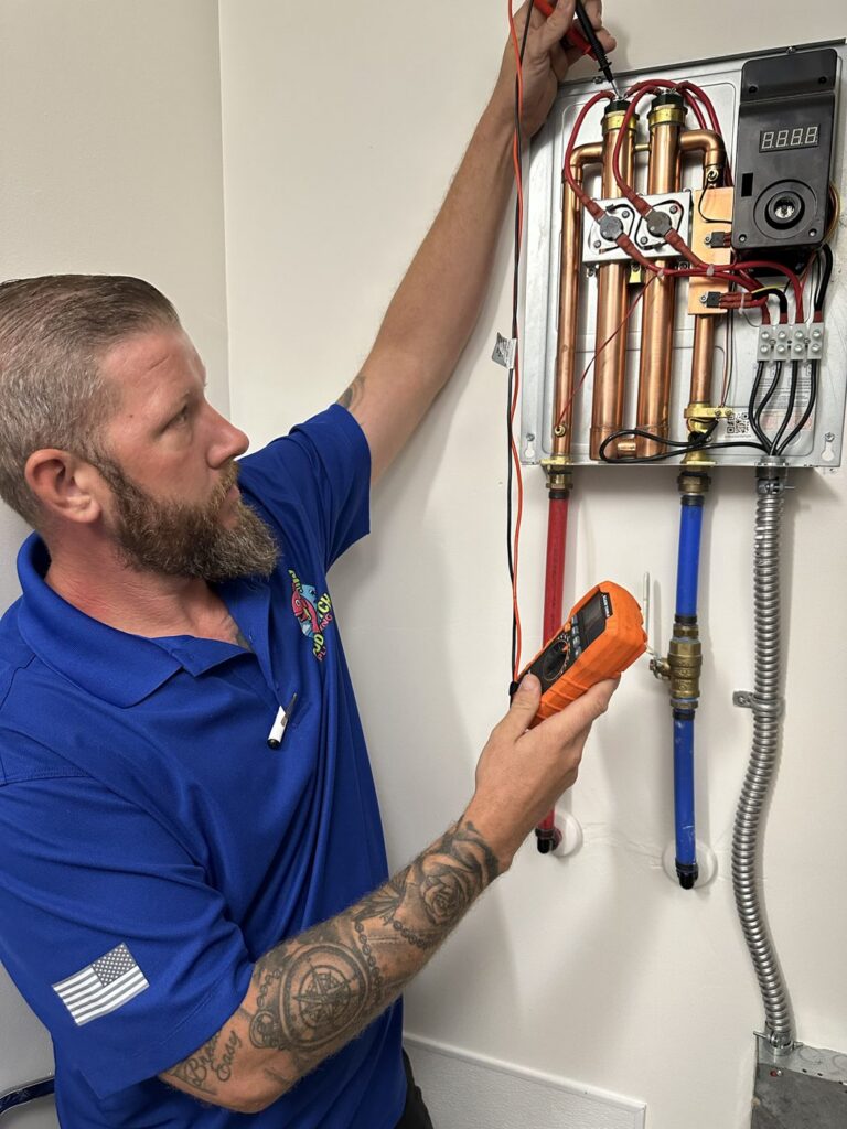 Good Catch Plumbing technician servicing a wall-mounted tankless water heater